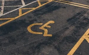 A handicap parking space with a yellow wheelchair symbol