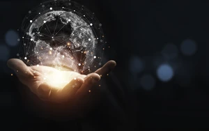 Hand holding a glowing virtual globe with network connections