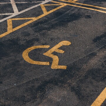 © Photographer: Jakub Pabis
Source: Unsplash A handicap parking space with a yellow wheelchair symbol